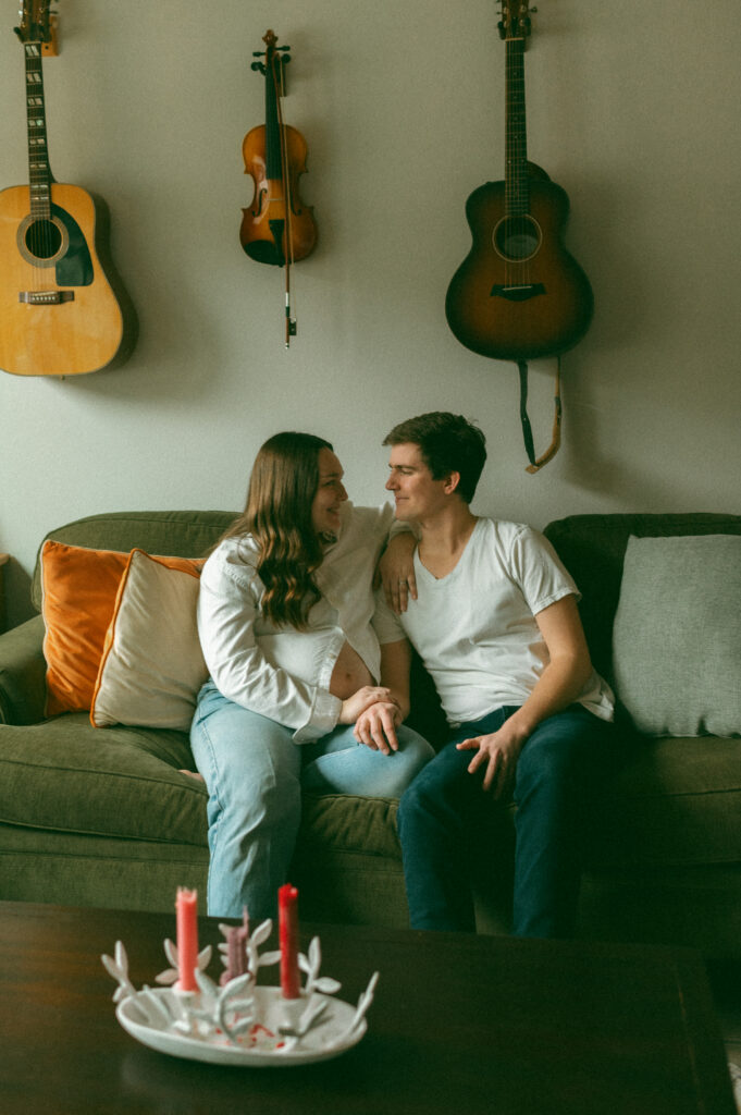 Relaxed maternity photo of expectant mother at home in cozy clothes, captured naturally.
