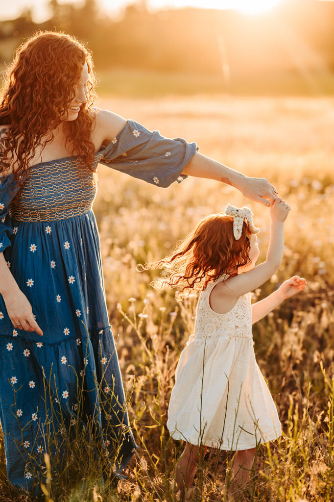 Spokane mom and daughter spinning in the golden light 